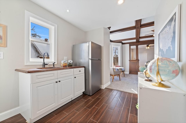 405 7th St S, Virginia, MN 55792 - kitchen featuring freestanding refrigerator, baseboards, a sink, dark wood-style flooring, and beamed ceiling