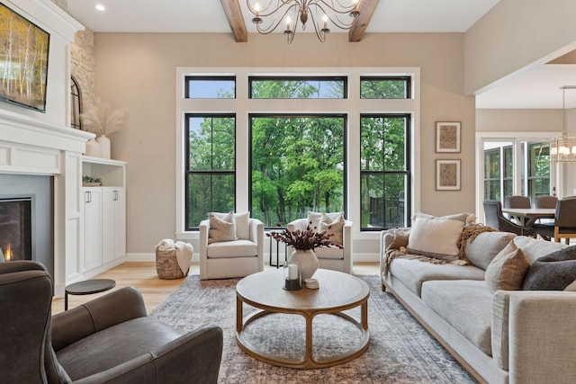 1432 25th St, Saint Joseph Twp, WI 54082 - living area featuring a chandelier, light wood finished floors, beam ceiling, plenty of natural light, and a warm lit fireplace