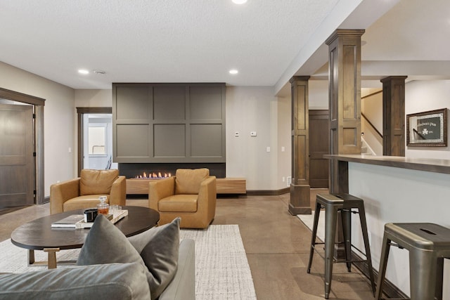 1432 25th St, Saint Joseph Twp, WI 54082 - living room with recessed lighting, baseboards, finished concrete floors, a textured ceiling, and decorative columns