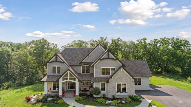 1432 25th St, Saint Joseph Twp, WI 54082 - craftsman inspired home with a porch, stone siding, a front lawn, and a shingled roof