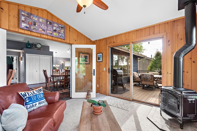 1665 Canary Ln, Mound, MN 55364 - carpeted living area with a wood stove, wooden walls, vaulted ceiling, and ceiling fan