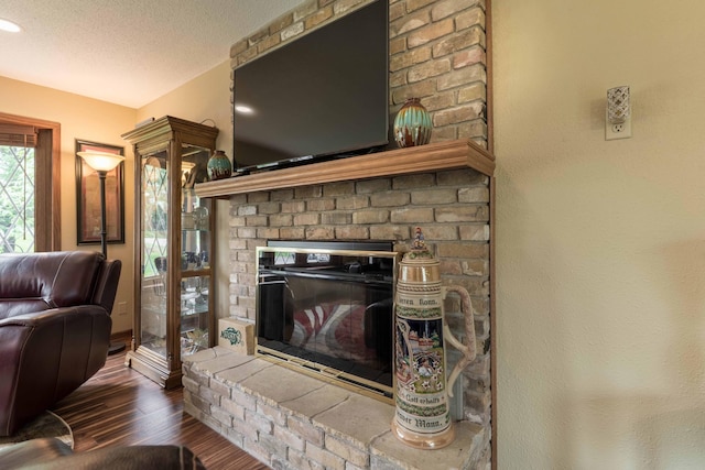 23725 240th Ave, Aurdal Twp, MN 56537 - living room featuring wood finished floors, a brick fireplace, and a textured ceiling