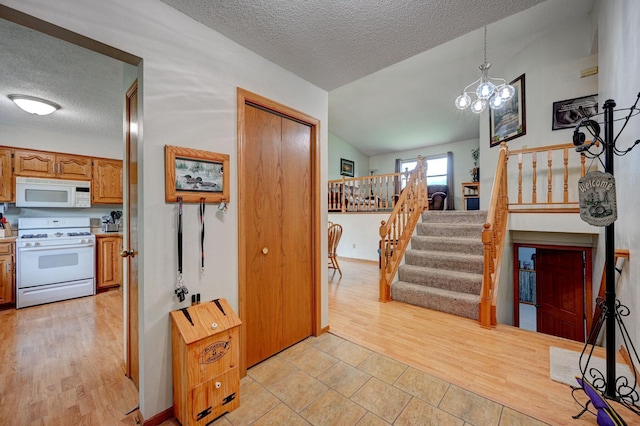 106 4th Ave NW, Rice, MN 56367 - entrance foyer featuring a textured ceiling, stairs, lofted ceiling, a chandelier, and light tile patterned floors