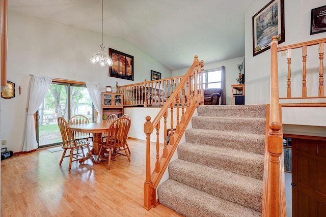 106 4th Ave NW, Rice, MN 56367 - dining room featuring stairs, wood finished floors, a chandelier, and high vaulted ceiling