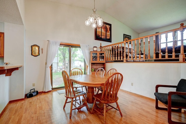 106 4th Ave NW, Rice, MN 56367 - dining area with light wood-style floors, a chandelier, high vaulted ceiling, and baseboards