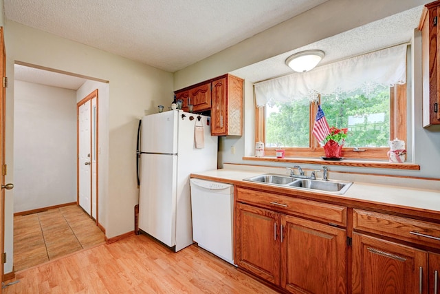 106 4th Ave NW, Rice, MN 56367 - kitchen with white appliances, a sink, light countertops, brown cabinets, and a textured ceiling
