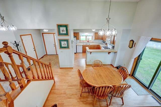 106 4th Ave NW, Rice, MN 56367 - dining area featuring a chandelier, high vaulted ceiling, light wood finished floors, and stairs