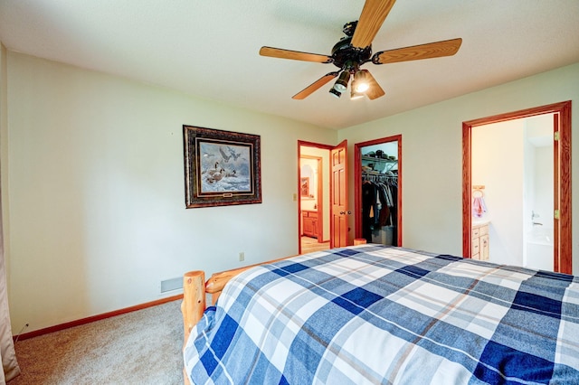 106 4th Ave NW, Rice, MN 56367 - carpeted bedroom featuring connected bathroom, a walk in closet, a closet, and baseboards