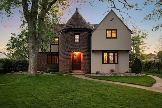 808 4th St SW, Austin, MN 55912 - view of front of house featuring a yard, brick siding, stucco siding, and a tile roof