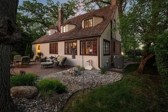 808 4th St SW, Austin, MN 55912 - rear view of property with a chimney, stucco siding, a patio, and an outdoor living space