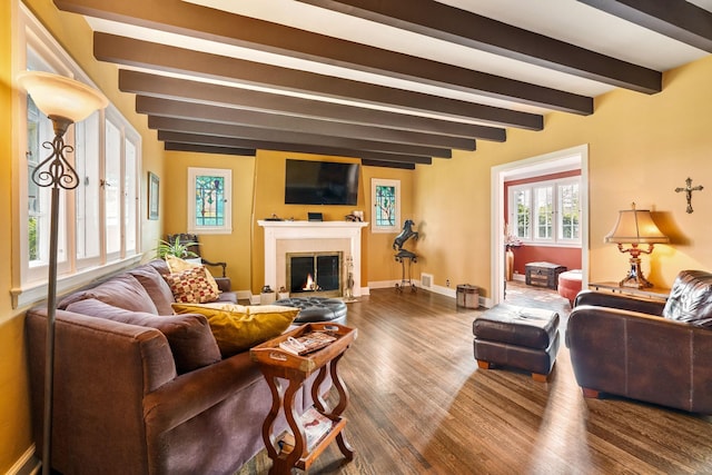 808 4th St SW, Austin, MN 55912 - living room with dark wood-style flooring, beam ceiling, a fireplace with flush hearth, and baseboards