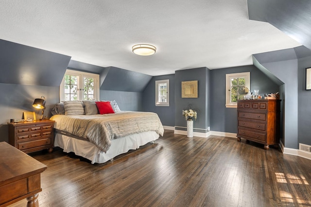 808 4th St SW, Austin, MN 55912 - bedroom featuring dark wood-style flooring, multiple windows, baseboards, and vaulted ceiling