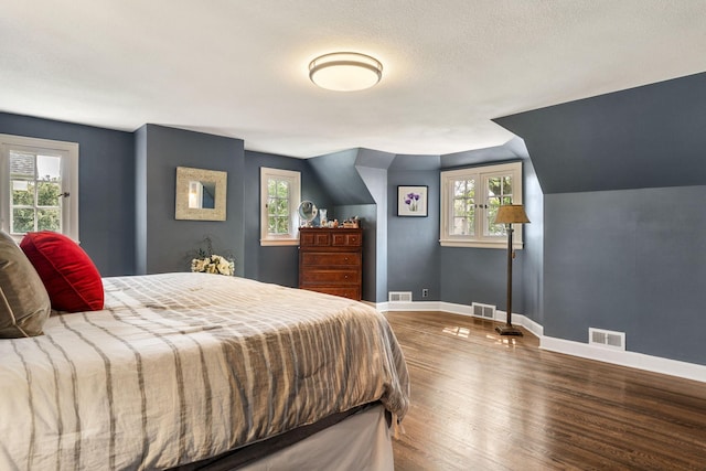 808 4th St SW, Austin, MN 55912 - bedroom with wood finished floors, baseboards, multiple windows, and lofted ceiling