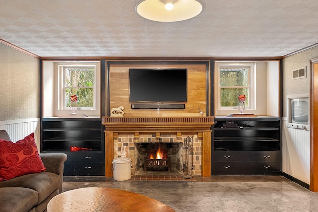 808 4th St SW, Austin, MN 55912 - living area featuring finished concrete floors, plenty of natural light, ornamental molding, and a warm lit fireplace