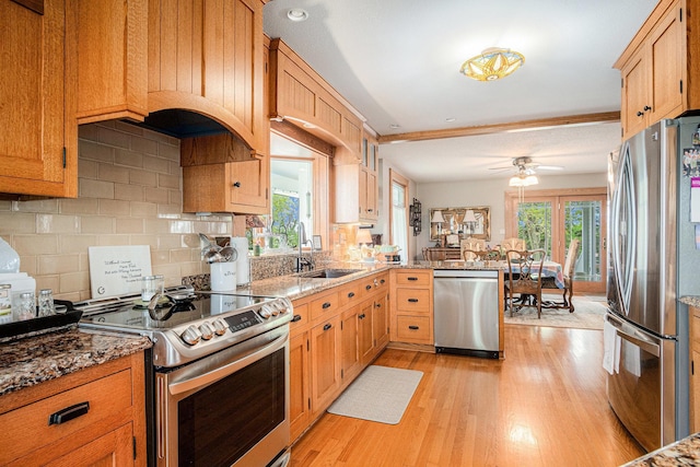 102 Walnut Ave, Luverne, MN 56156 - kitchen with stainless steel appliances, a sink, light wood finished floors, a peninsula, and light stone countertops