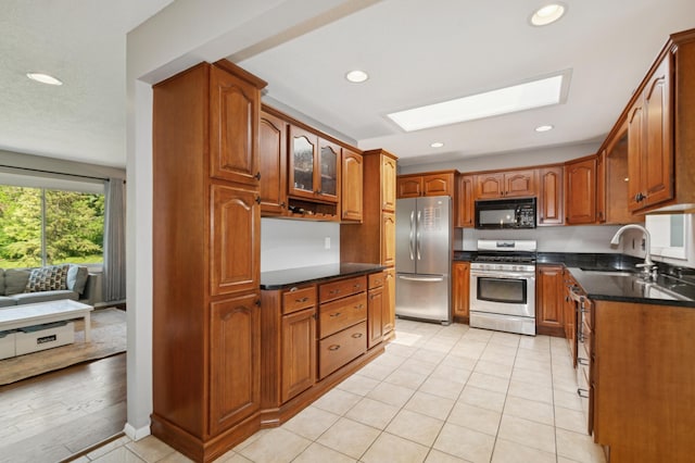 15613 Boulder Creek Dr, Minnetonka, MN 55345 - kitchen with stainless steel appliances, a skylight, a sink, brown cabinetry, and recessed lighting