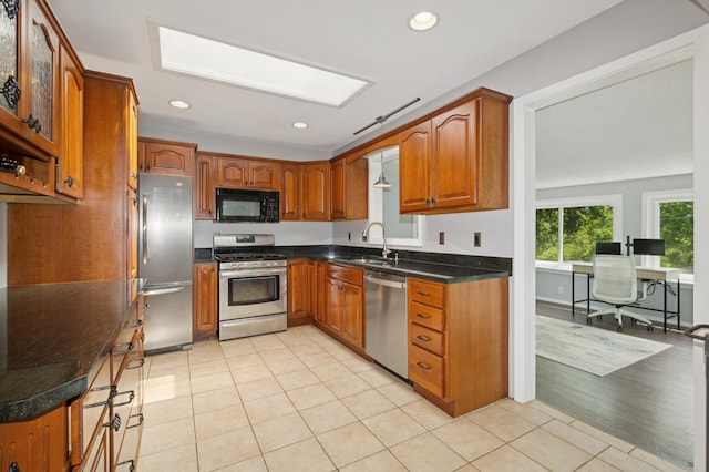 15613 Boulder Creek Dr, Minnetonka, MN 55345 - kitchen with appliances with stainless steel finishes, a skylight, a sink, brown cabinets, and an office area
