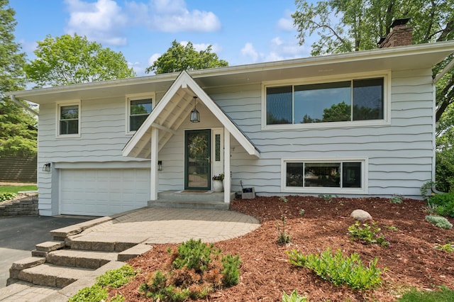 15613 Boulder Creek Dr, Minnetonka, MN 55345 - raised ranch featuring asphalt driveway, a chimney, and an attached garage