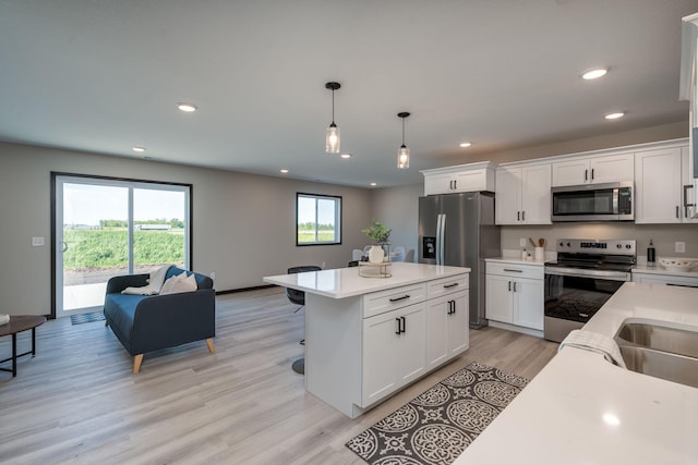 3203 Scotch Ln, Mankato, MN 56001 - kitchen featuring appliances with stainless steel finishes, light countertops, white cabinetry, light wood finished floors, and recessed lighting