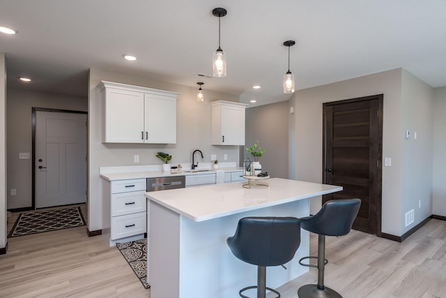 3203 Scotch Ln, Mankato, MN 56001 - kitchen with light wood-style floors, light countertops, white cabinets, a kitchen breakfast bar, and stainless steel dishwasher