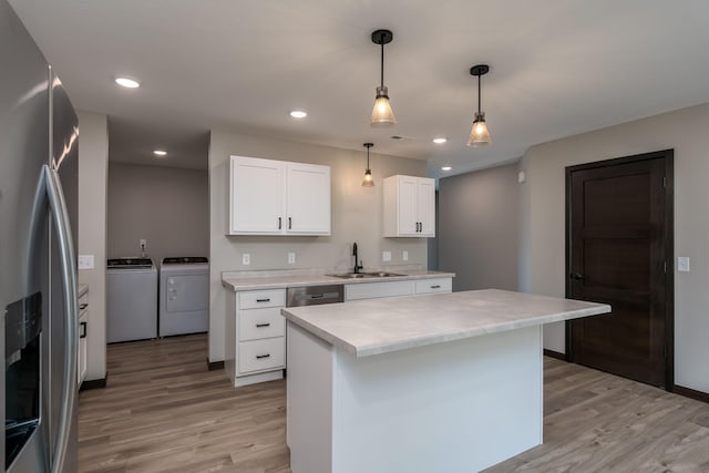 3120 Scotch Ln, Mankato, MN 56001 - kitchen with stainless steel appliances, washing machine and dryer, a sink, light wood finished floors, and light countertops
