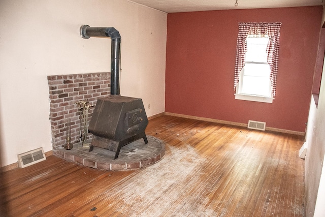 808 Franklin Ave, Wabasha, MN 55981 - unfurnished living room with a wood stove, hardwood / wood-style flooring, and baseboards