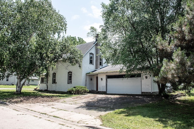 808 Franklin Ave, Wabasha, MN 55981 - obstructed view of property with asphalt driveway, a garage, a front lawn, a chimney, and roof with shingles