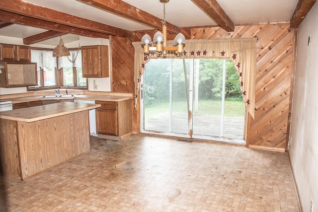 808 Franklin Ave, Wabasha, MN 55981 - kitchen featuring dishwashing machine, wood walls, beamed ceiling, brick patterned flooring, and a chandelier