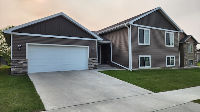 5687 Prosper Ave NW, Rochester, MN 55901 - view of front of property with a front lawn, stone siding, concrete driveway, and a garage