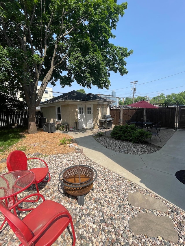 2518 Blaisdell Ave S Unit 1, Minneapolis, MN 55404 - rear view of property with a fenced backyard, a patio, an outdoor fire pit, and stucco siding