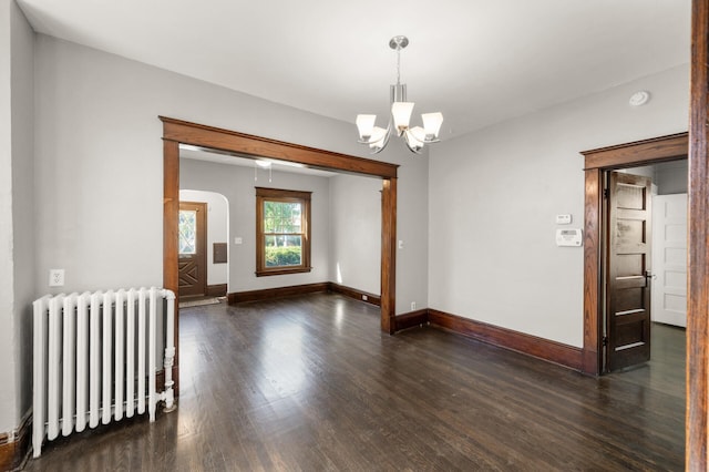 1195 Minnehaha Ave E, Saint Paul, MN 55106 - spare room with radiator heating unit, dark wood-style flooring, a chandelier, and baseboards