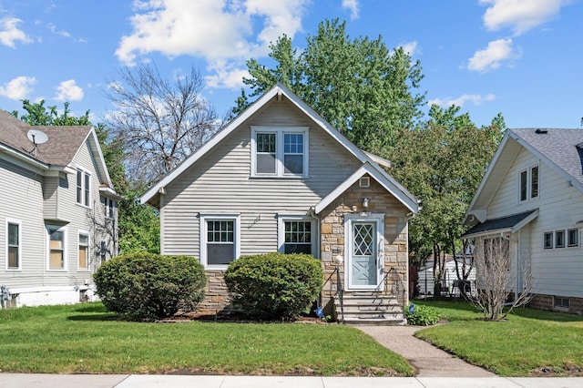 1195 Minnehaha Ave E, Saint Paul, MN 55106 - view of front of house with stone siding, a front yard, and entry steps