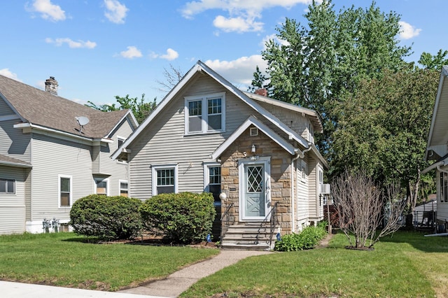 1195 Minnehaha Ave E, Saint Paul, MN 55106 - view of front of home with stone siding, a front lawn, and a chimney