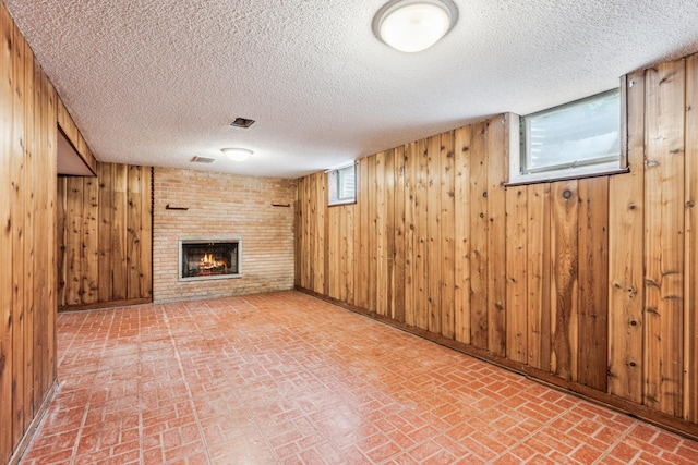 15812 Woodgate Rd N, Minnetonka, MN 55345 - basement with brick patterned flooring, wood walls, a brick fireplace, and a textured ceiling
