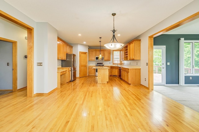 1469 Sherman Lake Rd, Lino Lakes, MN 55038 - kitchen with appliances with stainless steel finishes, a center island, light countertops, light wood-type flooring, and baseboards