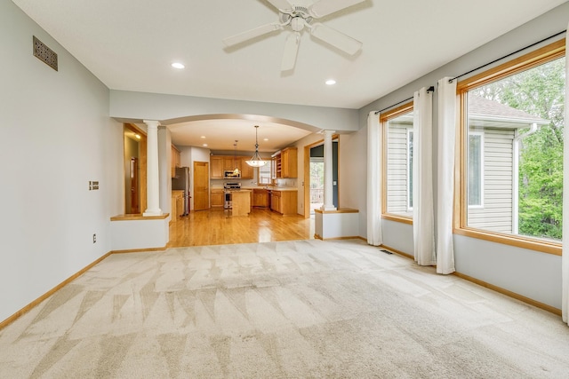 1469 Sherman Lake Rd, Lino Lakes, MN 55038 - unfurnished living room with ornate columns, light carpet, arched walkways, baseboards, and recessed lighting
