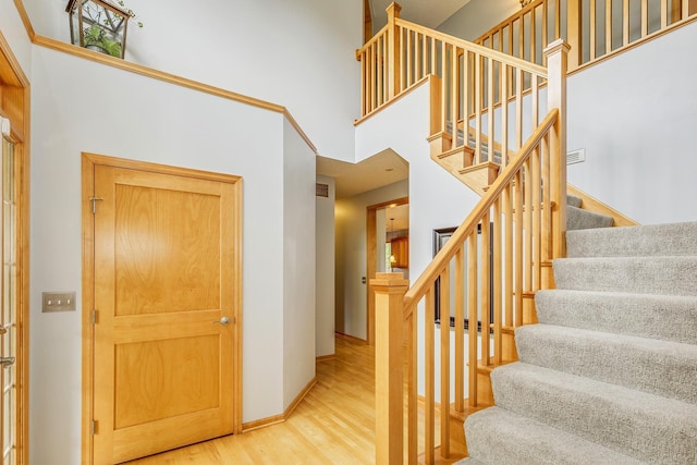 1469 Sherman Lake Rd, Lino Lakes, MN 55038 - staircase with wood finished floors, a towering ceiling, and baseboards
