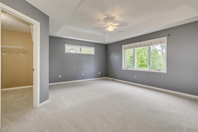 1469 Sherman Lake Rd, Lino Lakes, MN 55038 - empty room featuring a tray ceiling, carpet, ceiling fan, and baseboards