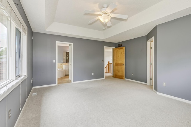 1469 Sherman Lake Rd, Lino Lakes, MN 55038 - unfurnished bedroom with a tray ceiling, light colored carpet, multiple windows, and baseboards