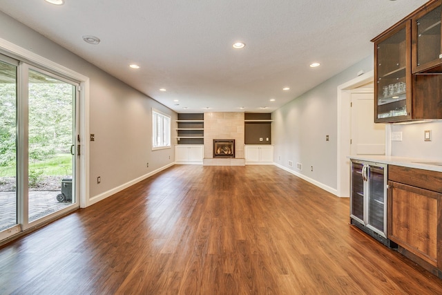1469 Sherman Lake Rd, Lino Lakes, MN 55038 - unfurnished living room featuring dark wood finished floors, healthy amount of natural light, baseboards, recessed lighting, and wine cooler