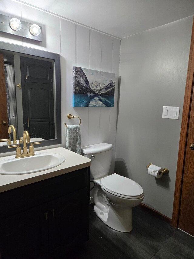 1410 16th St SW, Willmar, MN 56201 - bathroom with vanity, toilet, and wood finished floors