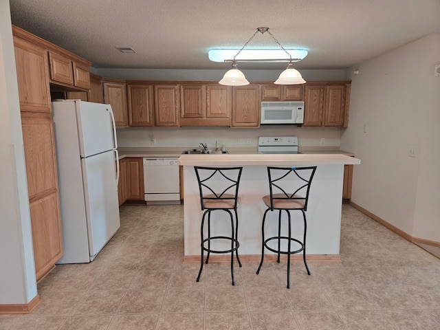 15631 Linnet St NW Unit 3-208, Andover, MN 55304 - kitchen featuring white appliances, a center island, light countertops, a kitchen breakfast bar, and a sink