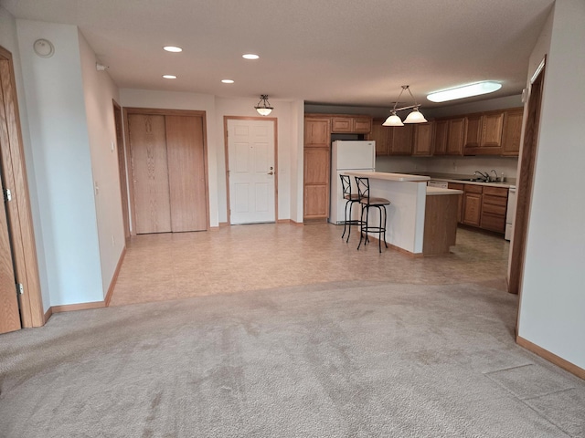 15631 Linnet St NW Unit 3-208, Andover, MN 55304 - kitchen with freestanding refrigerator, a breakfast bar, a sink, a kitchen island, and baseboards