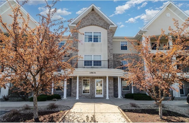 15631 Linnet St NW Unit 3-208, Andover, MN 55304 - townhome / multi-family property featuring a balcony, covered porch, stucco siding, and brick siding