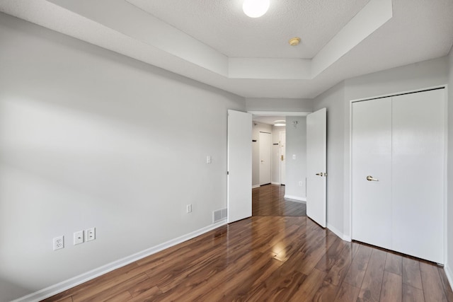 615 1st St Unit 405, Minneapolis, MN 55401 - unfurnished bedroom with wood finished floors, baseboards, a closet, and a textured ceiling