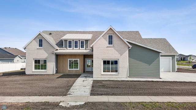 4295 Bristlecone Loop S, Fargo, ND 58104 - view of front of property featuring brick siding, metal roof, driveway, a garage, and a standing seam roof