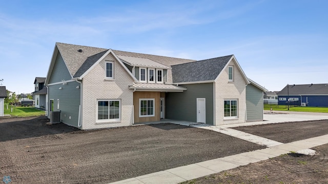 4295 Bristlecone Loop S, Fargo, ND 58104 - view of front facade featuring brick siding, a standing seam roof, metal roof, and a shingled roof