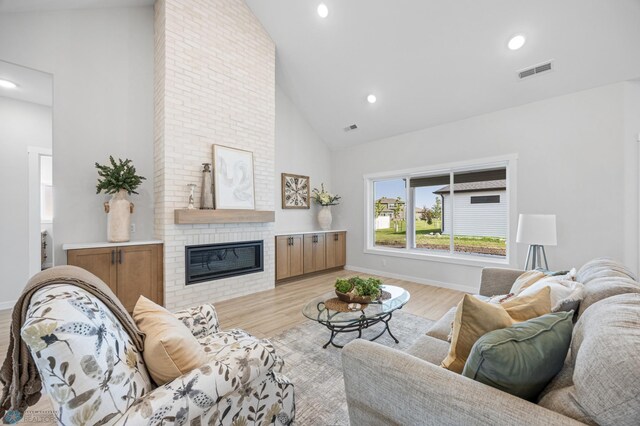 4295 Bristlecone Loop S, Fargo, ND 58104 - living area with high vaulted ceiling, a fireplace, light wood-style flooring, recessed lighting, and baseboards