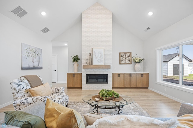 4295 Bristlecone Loop S, Fargo, ND 58104 - living room with a fireplace, high vaulted ceiling, light wood-style floors, and baseboards