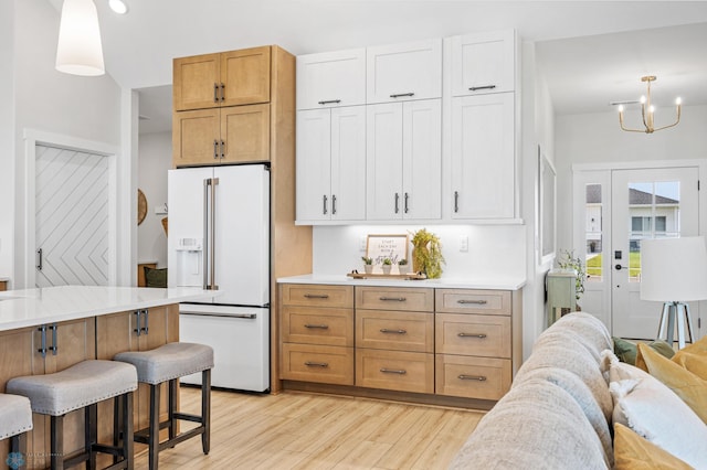 4295 Bristlecone Loop S, Fargo, ND 58104 - kitchen with high end white fridge, light wood-style floors, light countertops, a breakfast bar, and recessed lighting